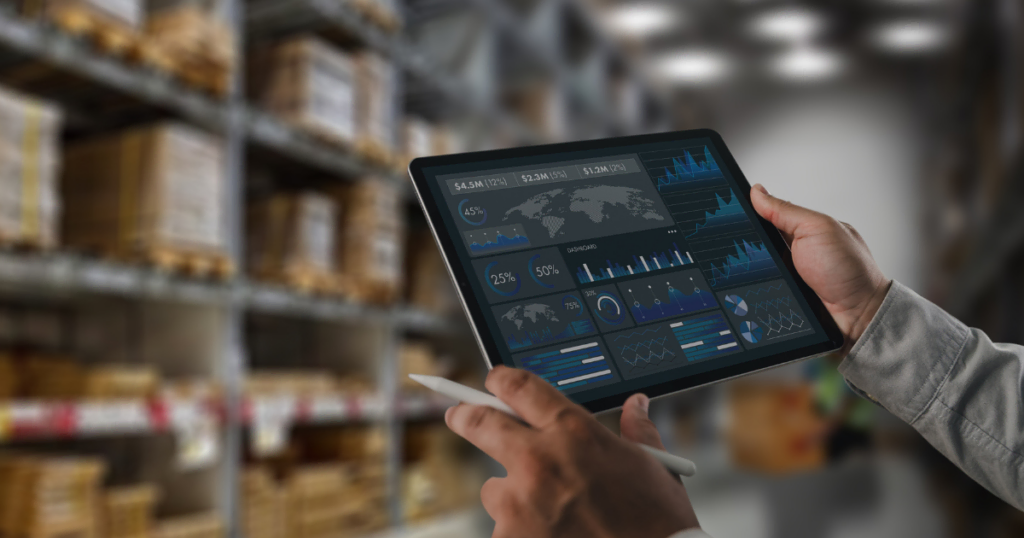 Person analyzing global e-commerce data on tablet in warehouse.